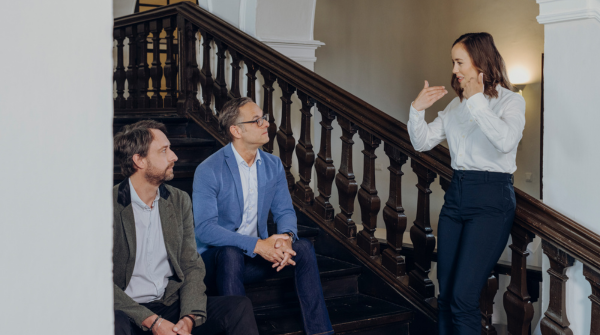 3 Personen an Treppe im Schloss